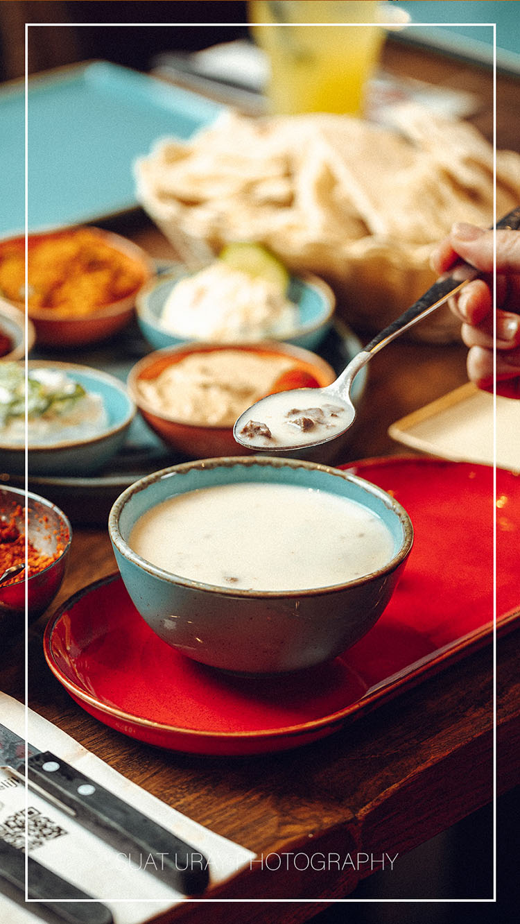 Sfeervolle afbeelding van İşkembe Çorbası, met warme tonen en uitnodigende presentatie.