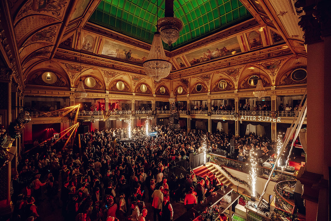 Party fotografie – energie, stijl en dynamiek vastgelegd Brede overzichtsfoto van een stijlvolle party met muziek en mensen in gesprek