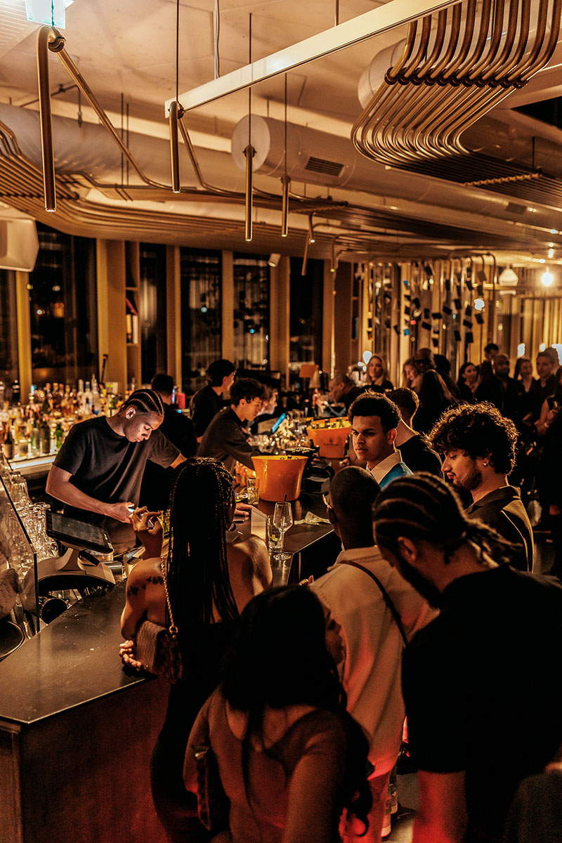 W Hotel Amsterdam rooftop event – stadse elegantie en nightlife gecombineerd Overzichtsfoto van W Hotel Amsterdam rooftop party met skyline en avondlicht