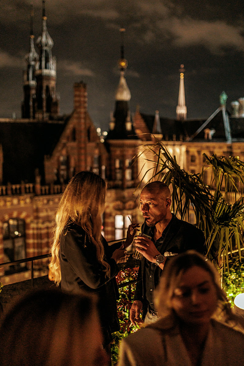 W Hotel Amsterdam rooftop fotografie – nachtleven met klasse en uitzicht Sfeervolle foto van rooftop party bij W Hotel Amsterdam met uitzicht over de stad