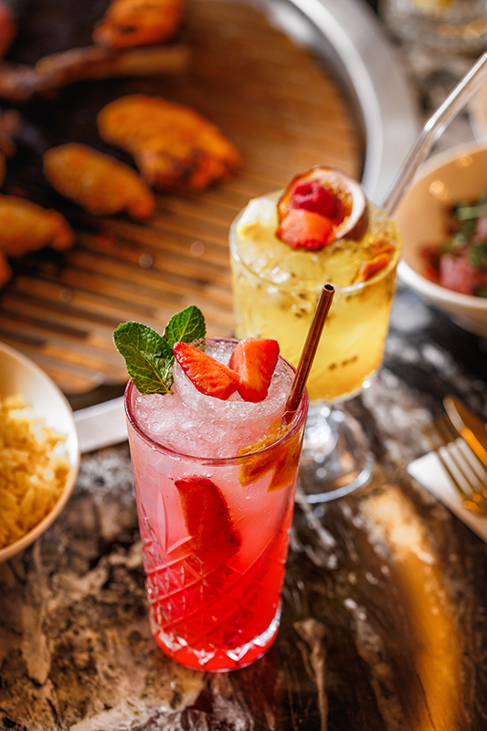 Sfeervolle foto van een rode mocktail met frisse presentatie en warm, natuurlijk licht.