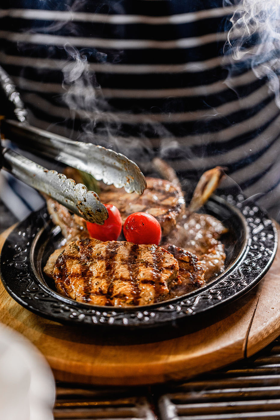 Sfeervolle foodfoto van gegrild vlees van de barbecue met warme tonen en natuurlijke belichting.
